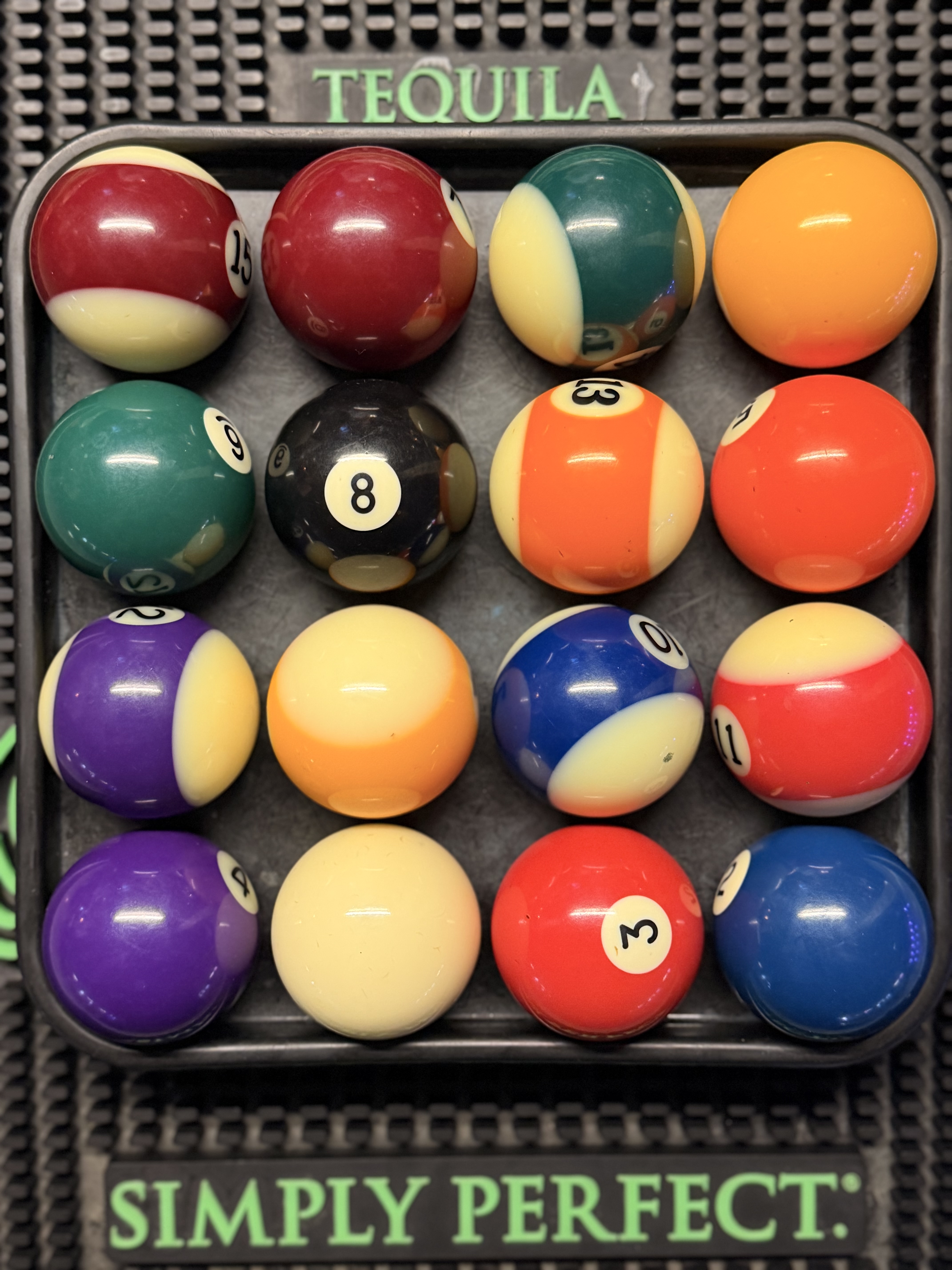 Colorful pool balls arranged in a tray