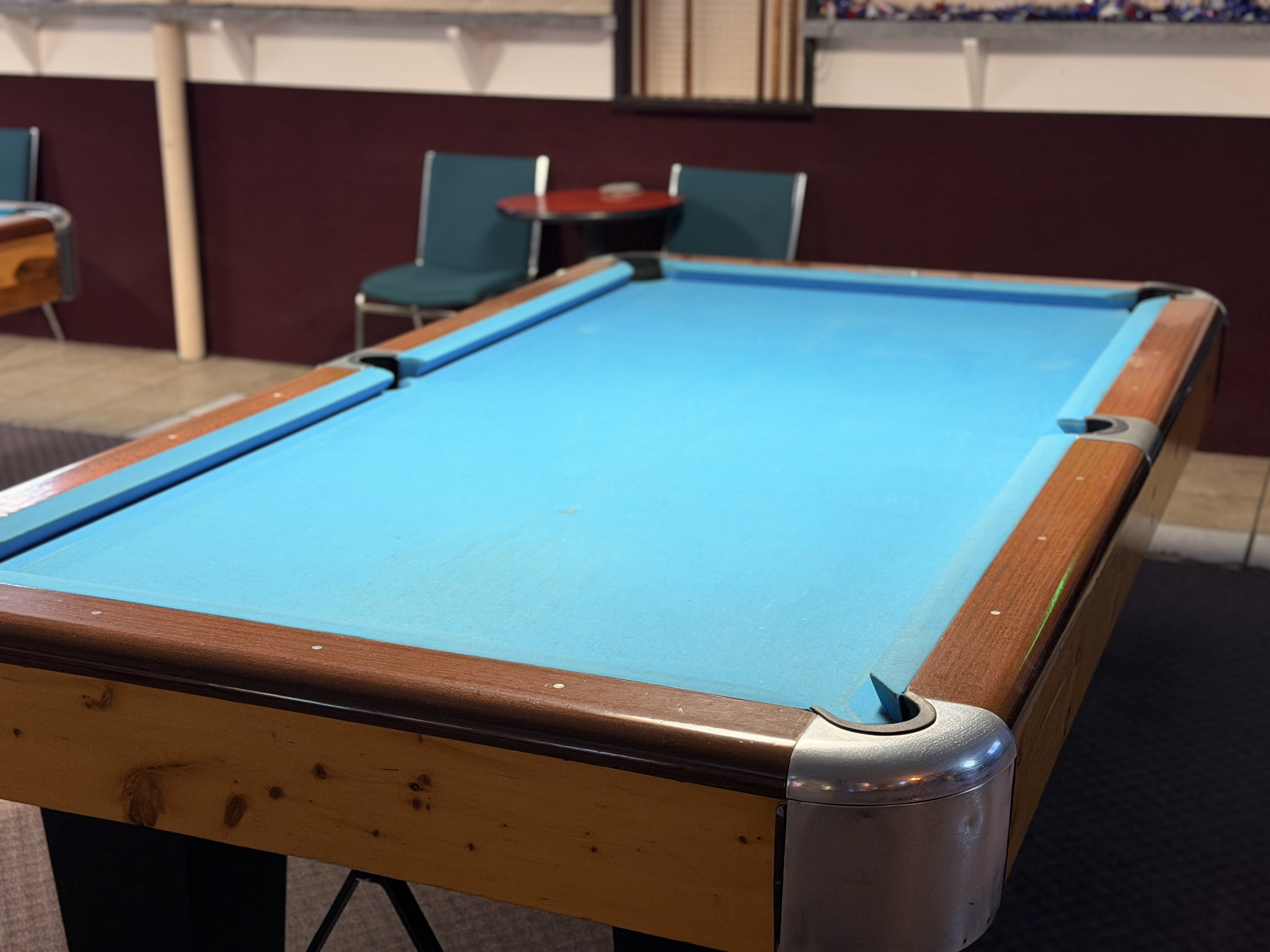 A tournament-blue felt pool table with lounge seating